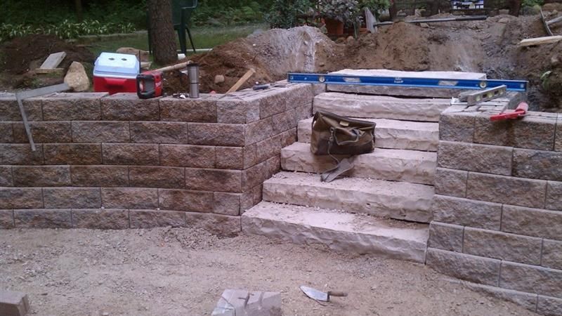 Stone steps and retaining walls under construction outdoors.