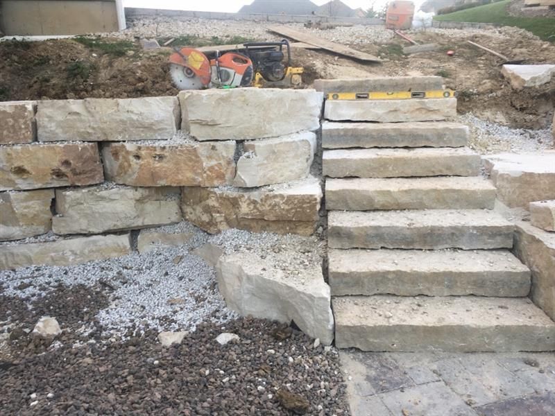 Stone steps and retaining wall under construction.