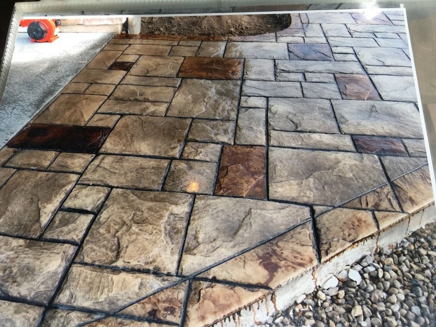 Stone-like stamped concrete patio with various rectangular and square shapes in shades of gray, brown, and tan.