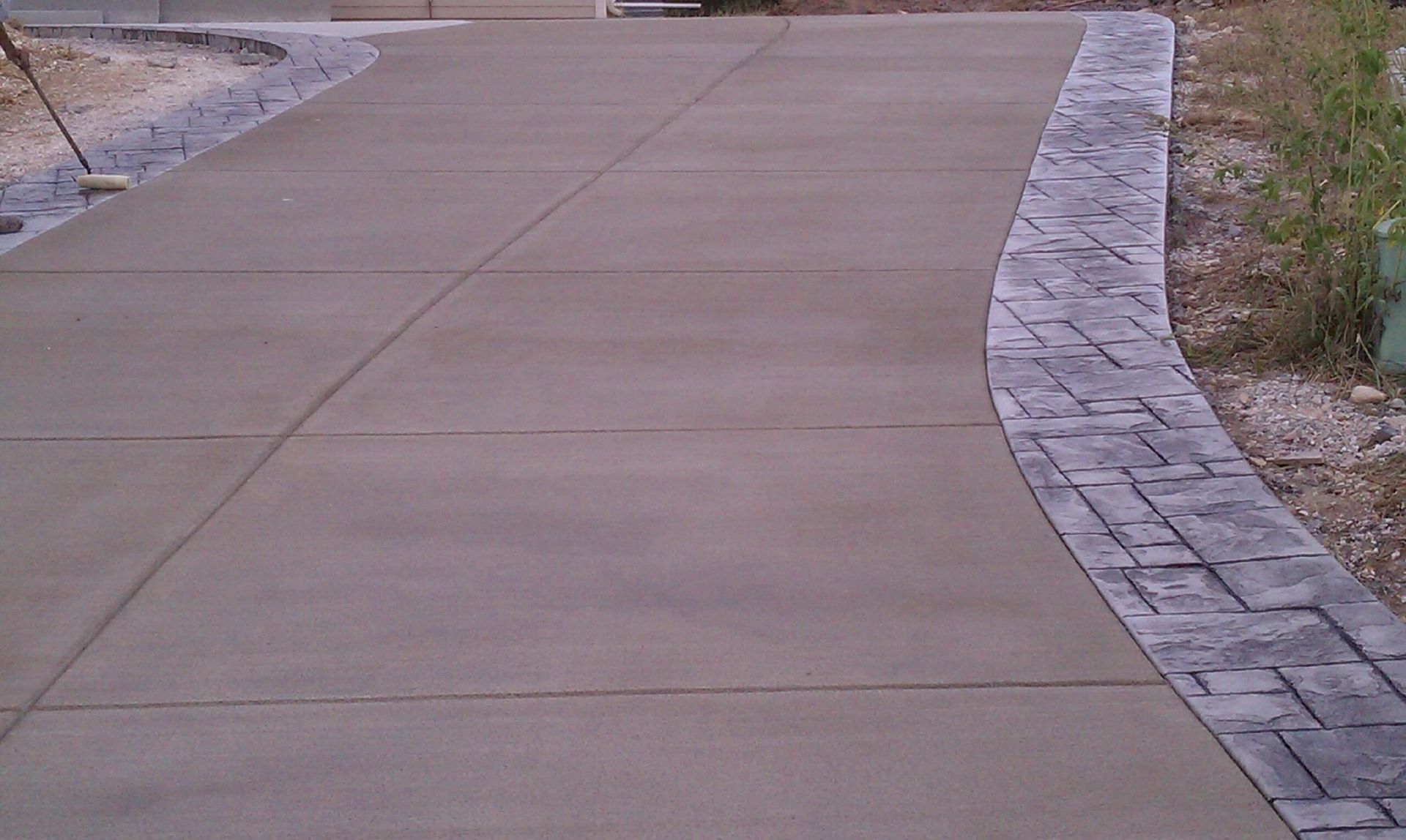 Concrete driveway with decorative stone border.