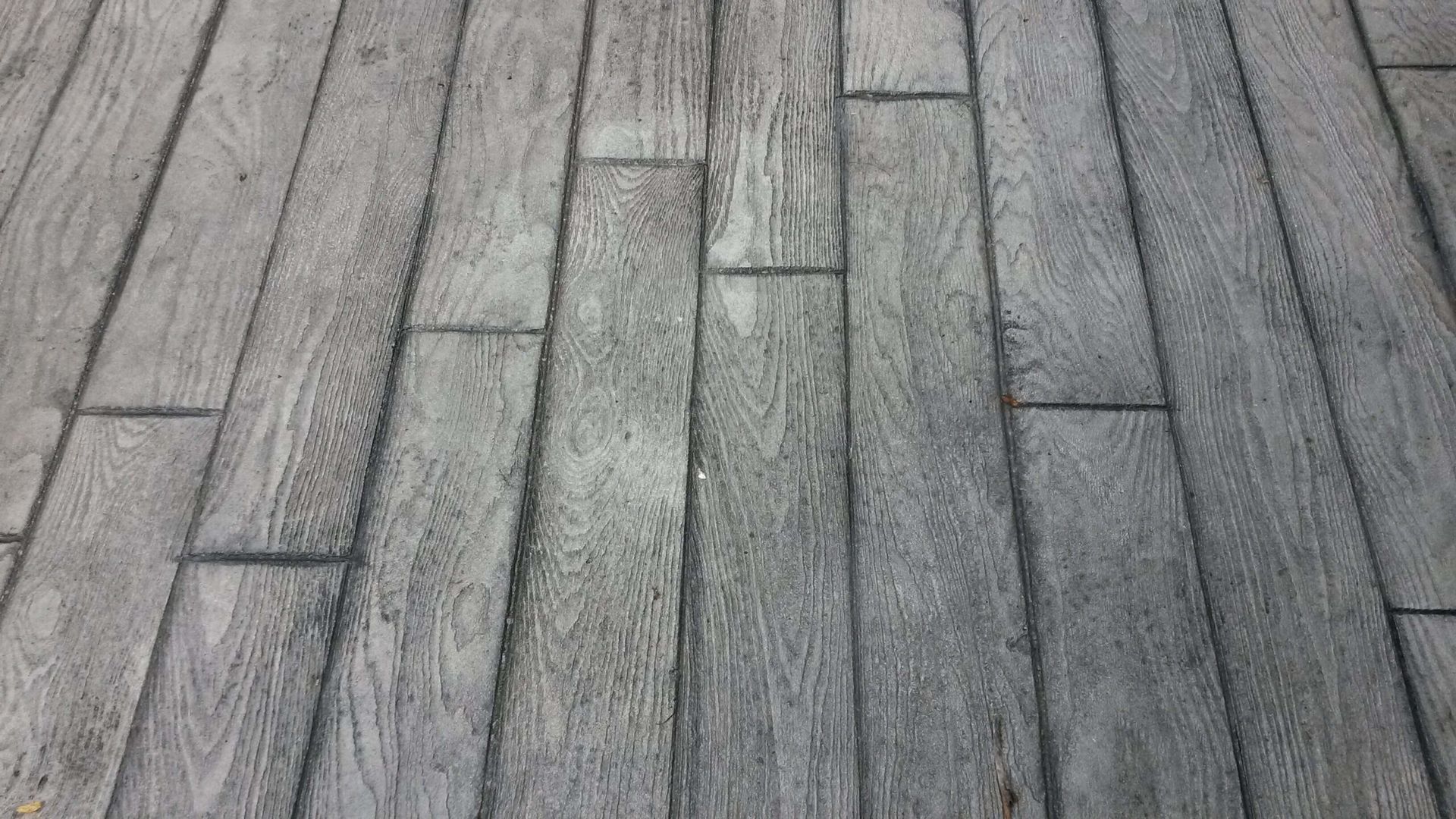 Gray concrete paving designed to look like wooden planks.