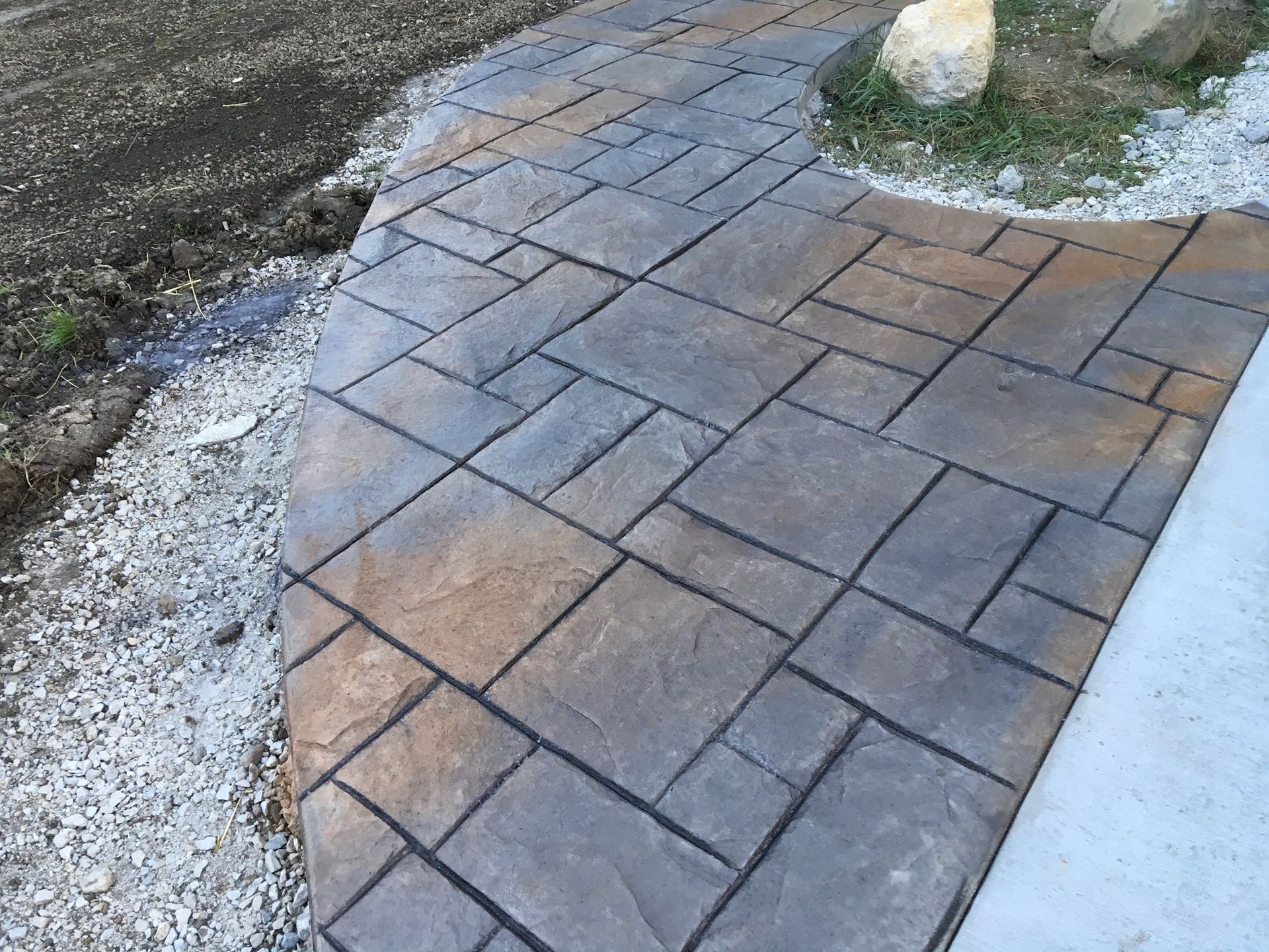 Stamped concrete walkway with brown and gray tones.