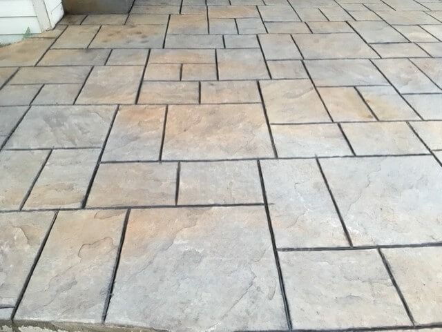 Stamped concrete patio with a flagstone pattern, gray and tan colors.