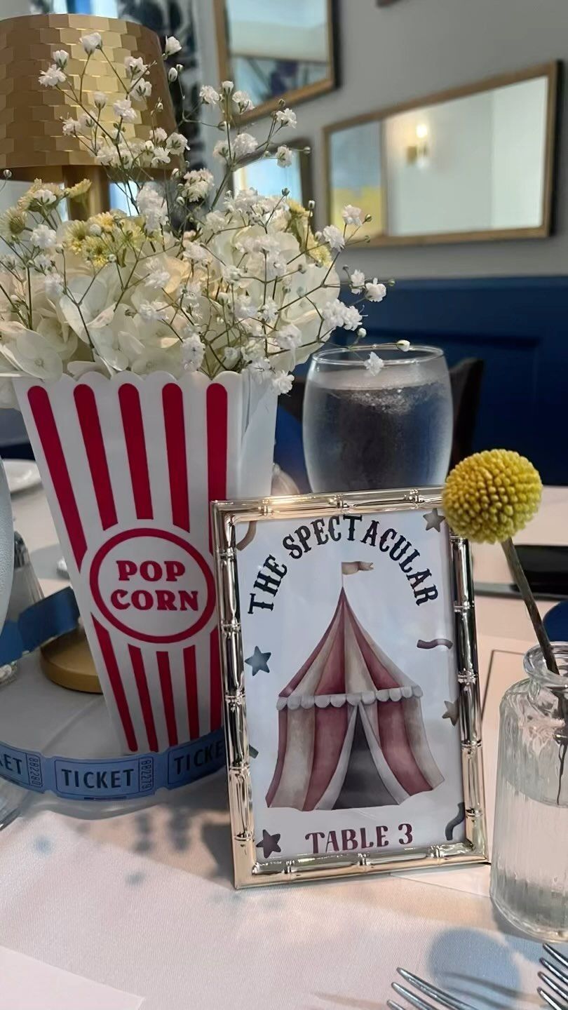 A table with a popcorn box and a sign that says `` the spectacular table ''.
