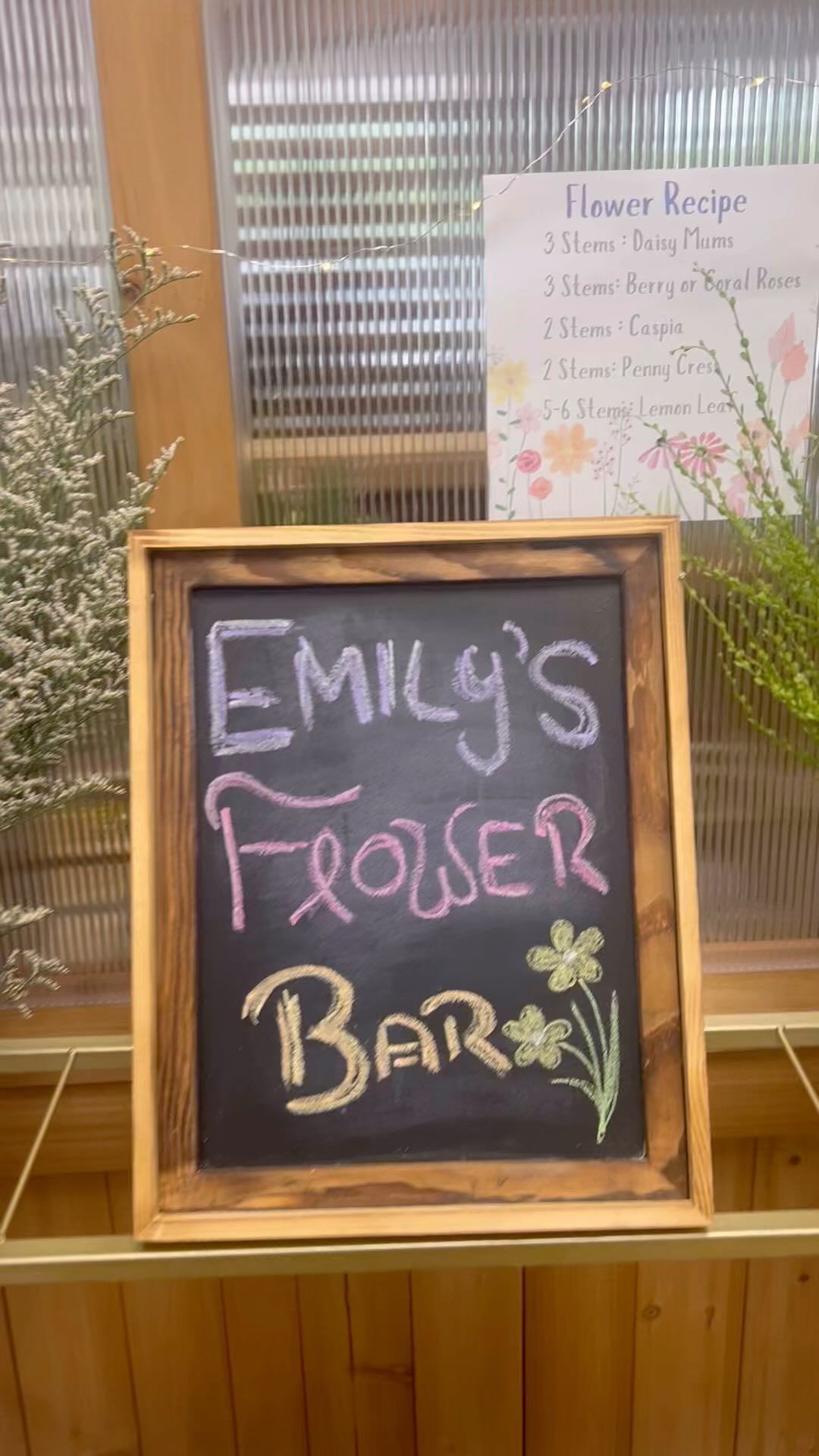 A blackboard with the words emily 's flower bar written on it.