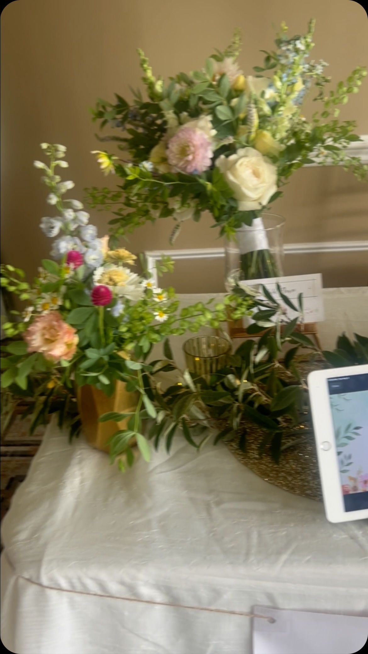 A table with flowers and a tablet on it.