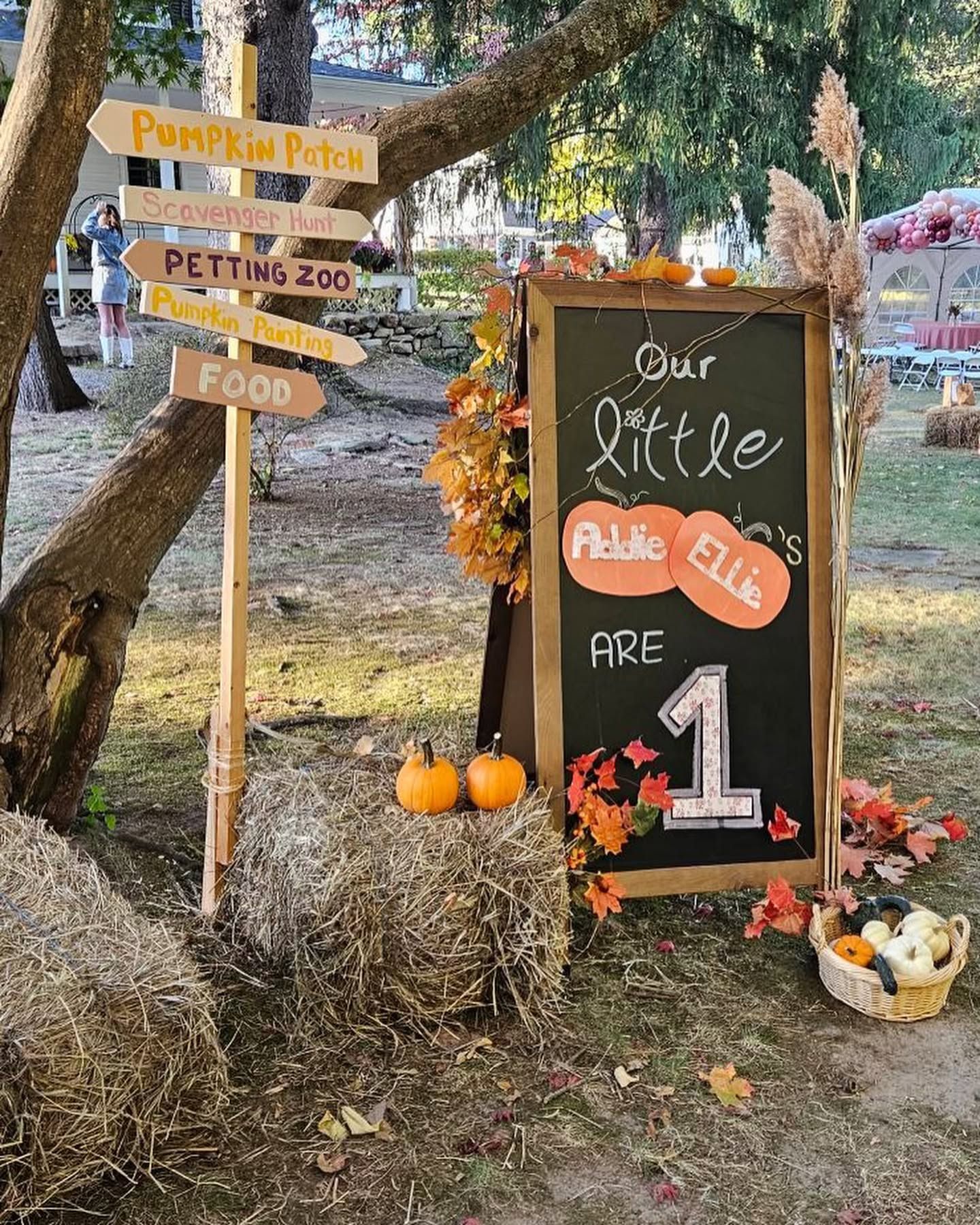A sign for a baby 's first birthday is sitting on top of hay bales.