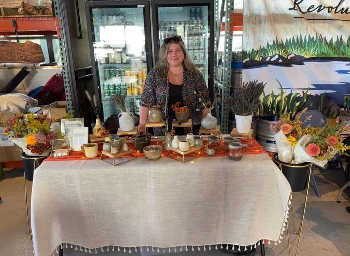 A woman is standing in front of a table with flowers on it.