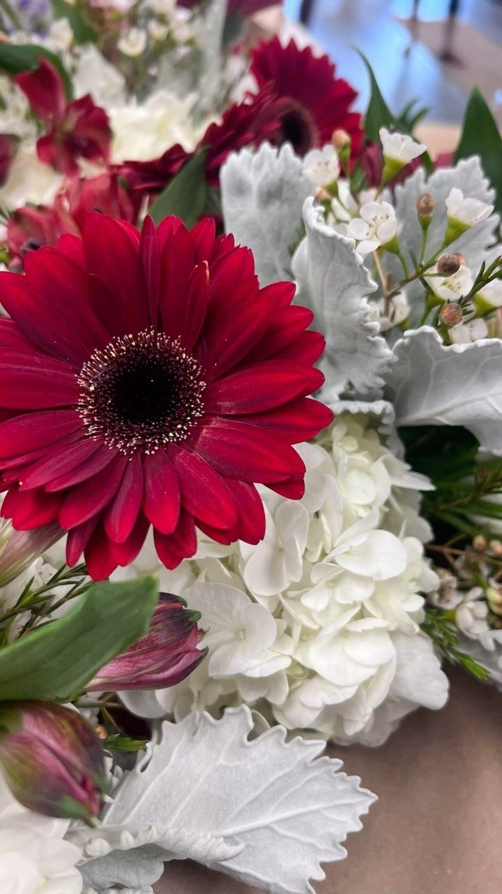 A bunch of red and white flowers are sitting on a table.
