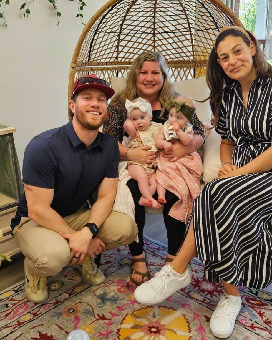 A group of people are posing for a picture while sitting in a wicker chair.
