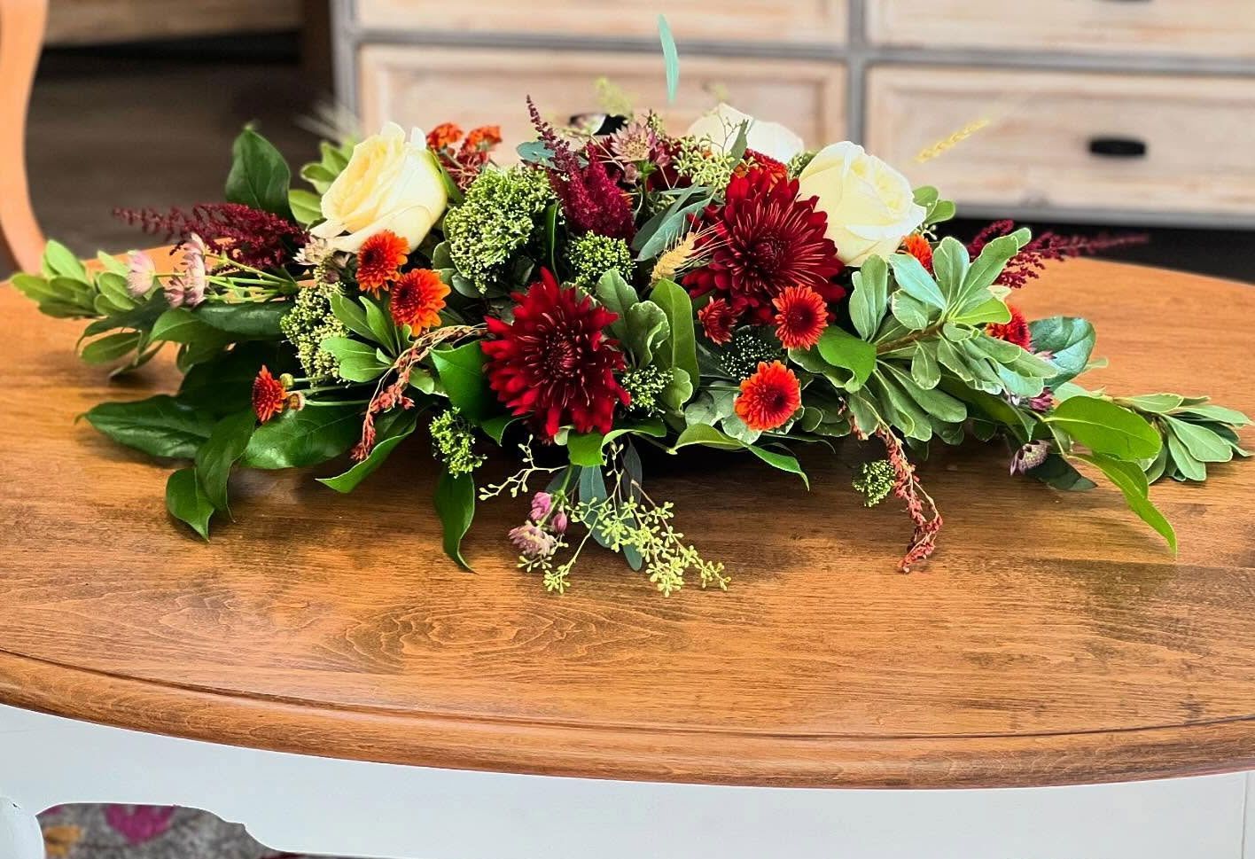 A bouquet of flowers is sitting on a wooden table.