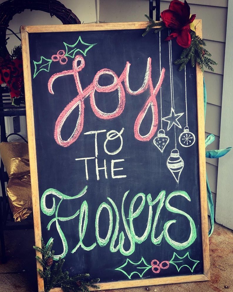 Chalkboard sign outside a flower shop reads