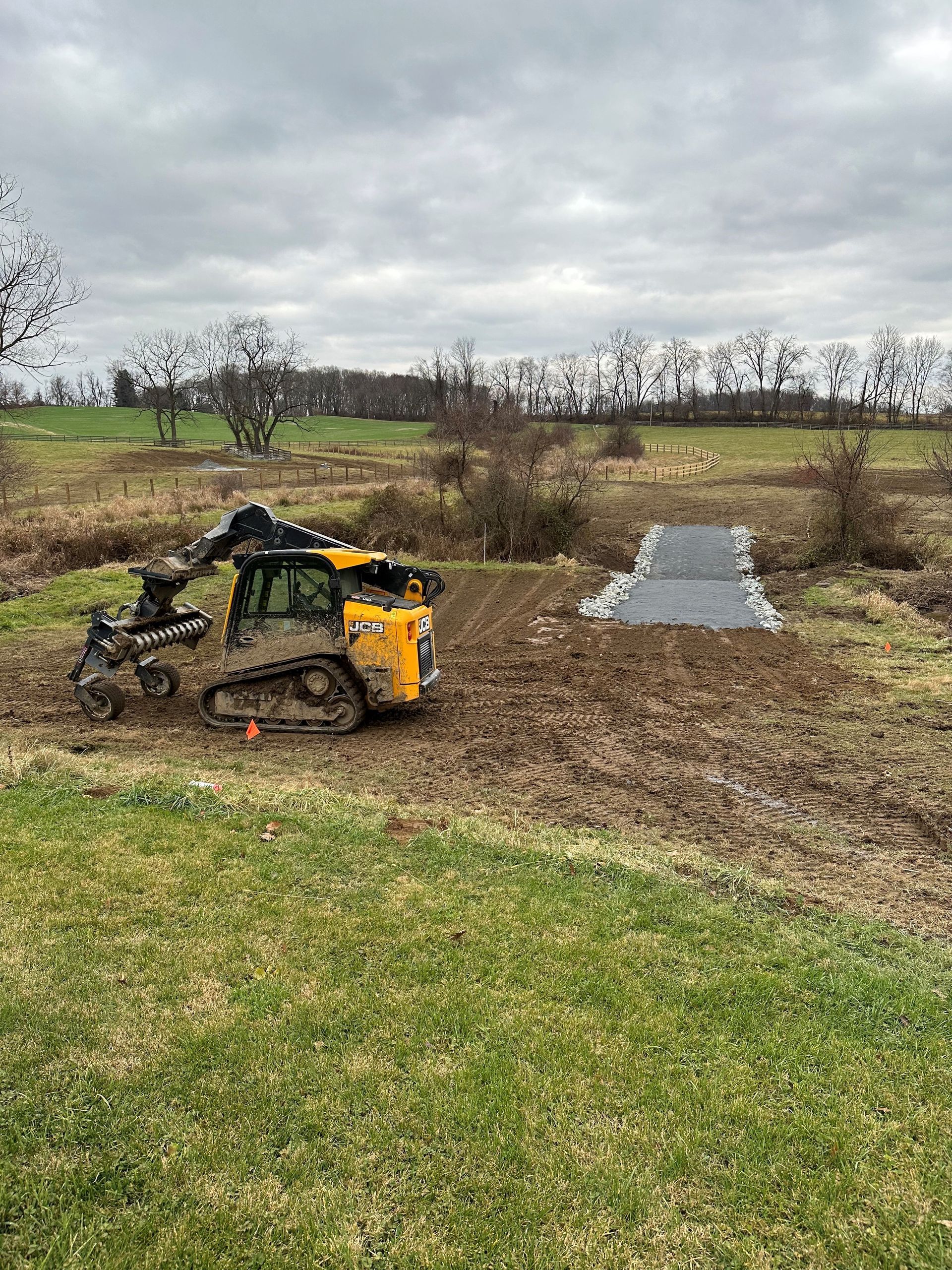 A yellow bulldozer is moving dirt in a field