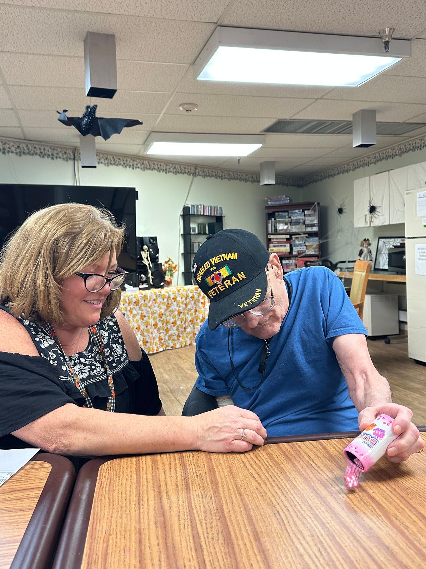 a man and a woman are sitting at a table in a room