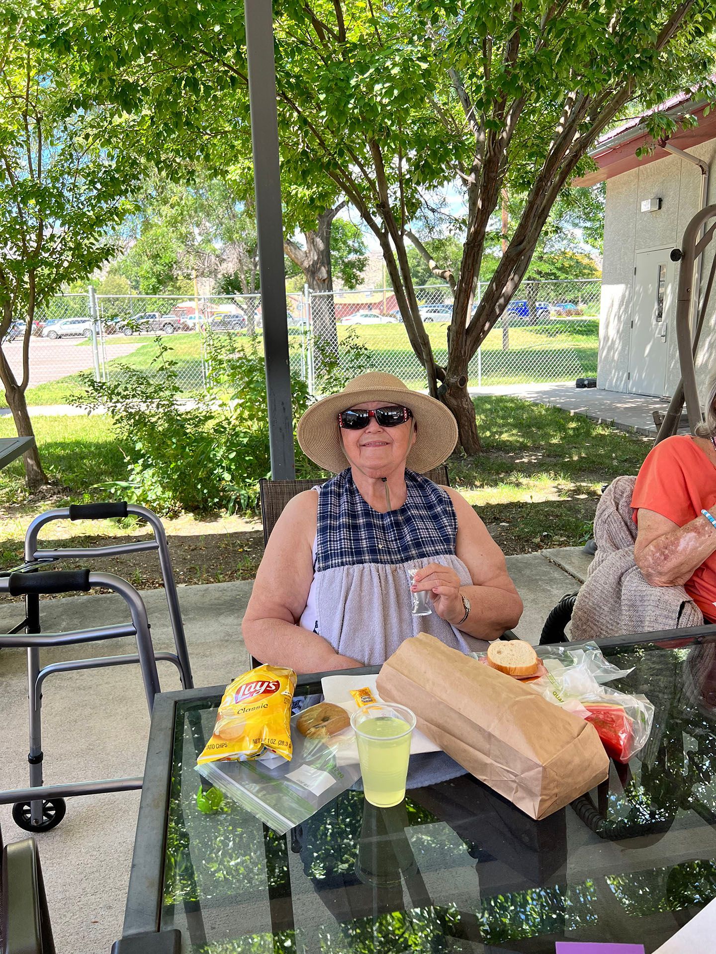 a woman is sitting at a table with a bag of chips on it
