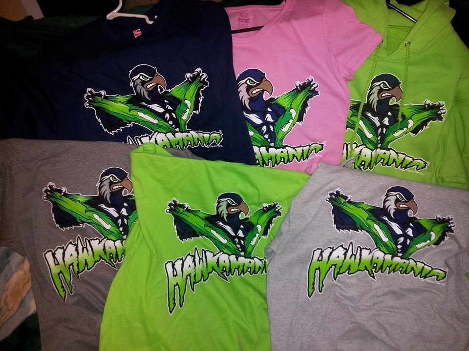Six t-shirts with a cartoon hawk design in various colors: navy, pink, two shades of green, and gray.