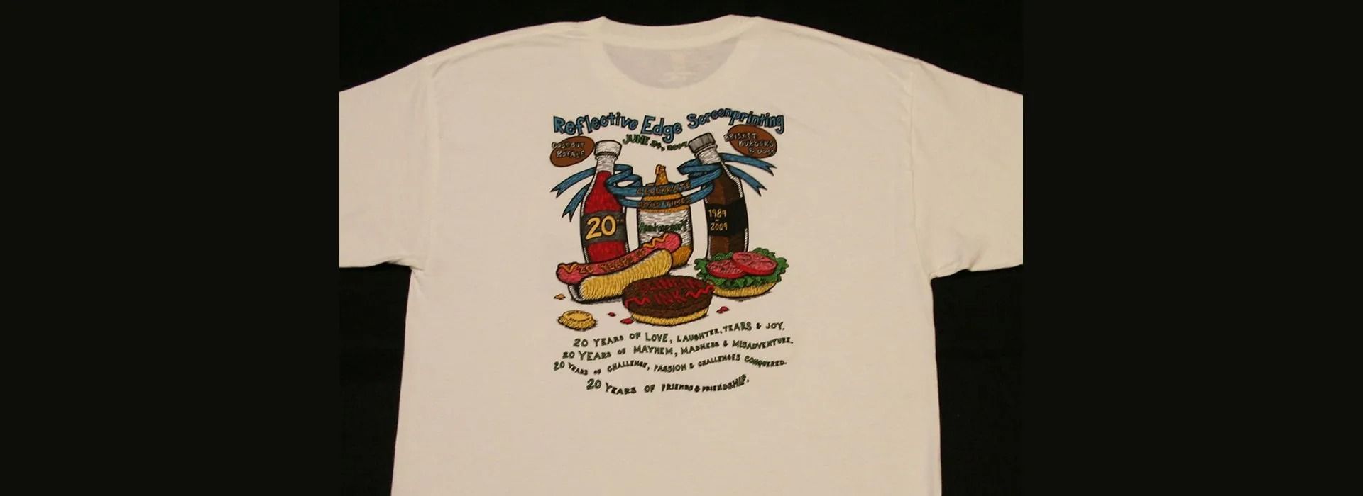 White t-shirt with print of hot dog, burger, and soda bottles with text.