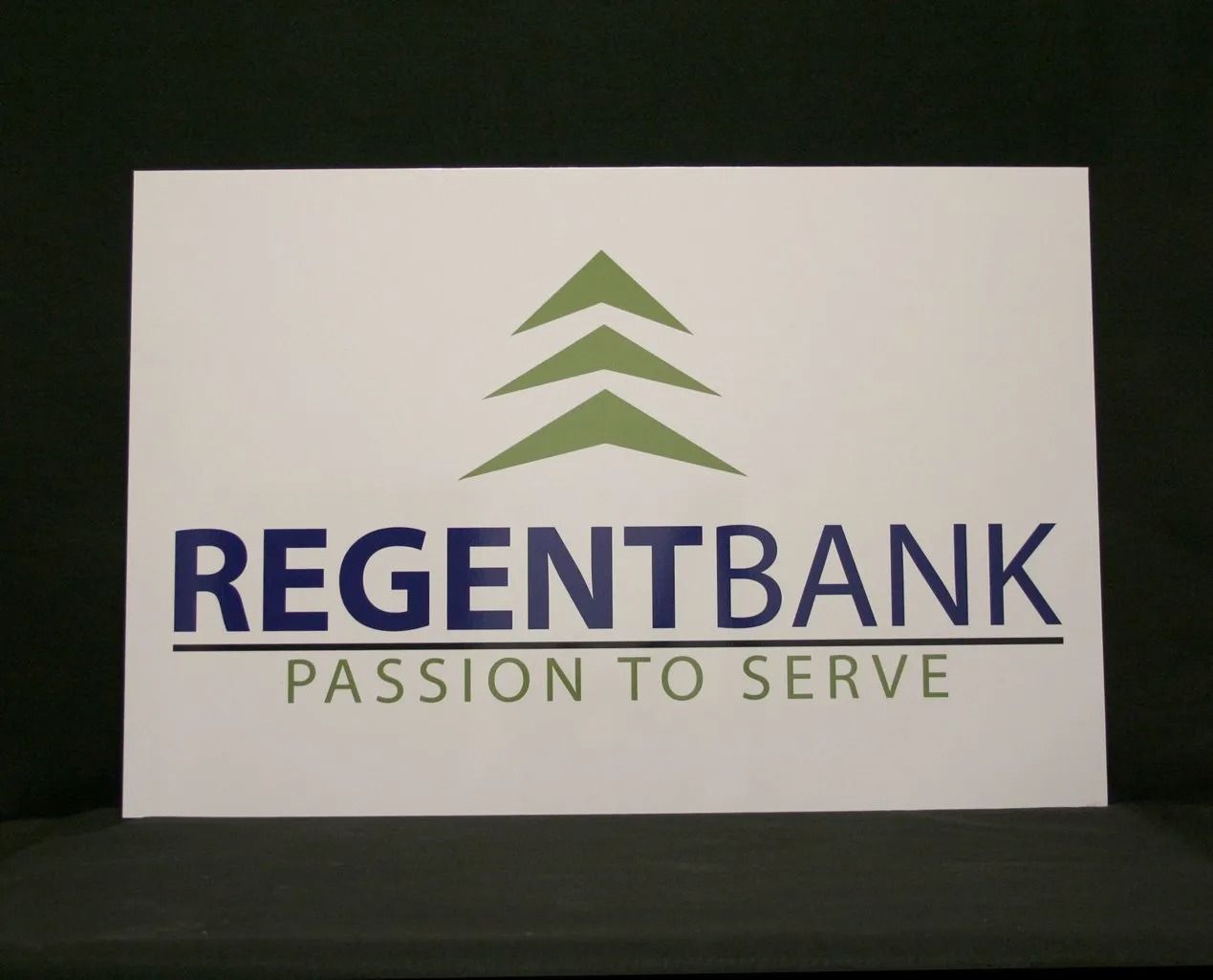 RegentBank logo on a white sign. Green tree icon over dark blue 