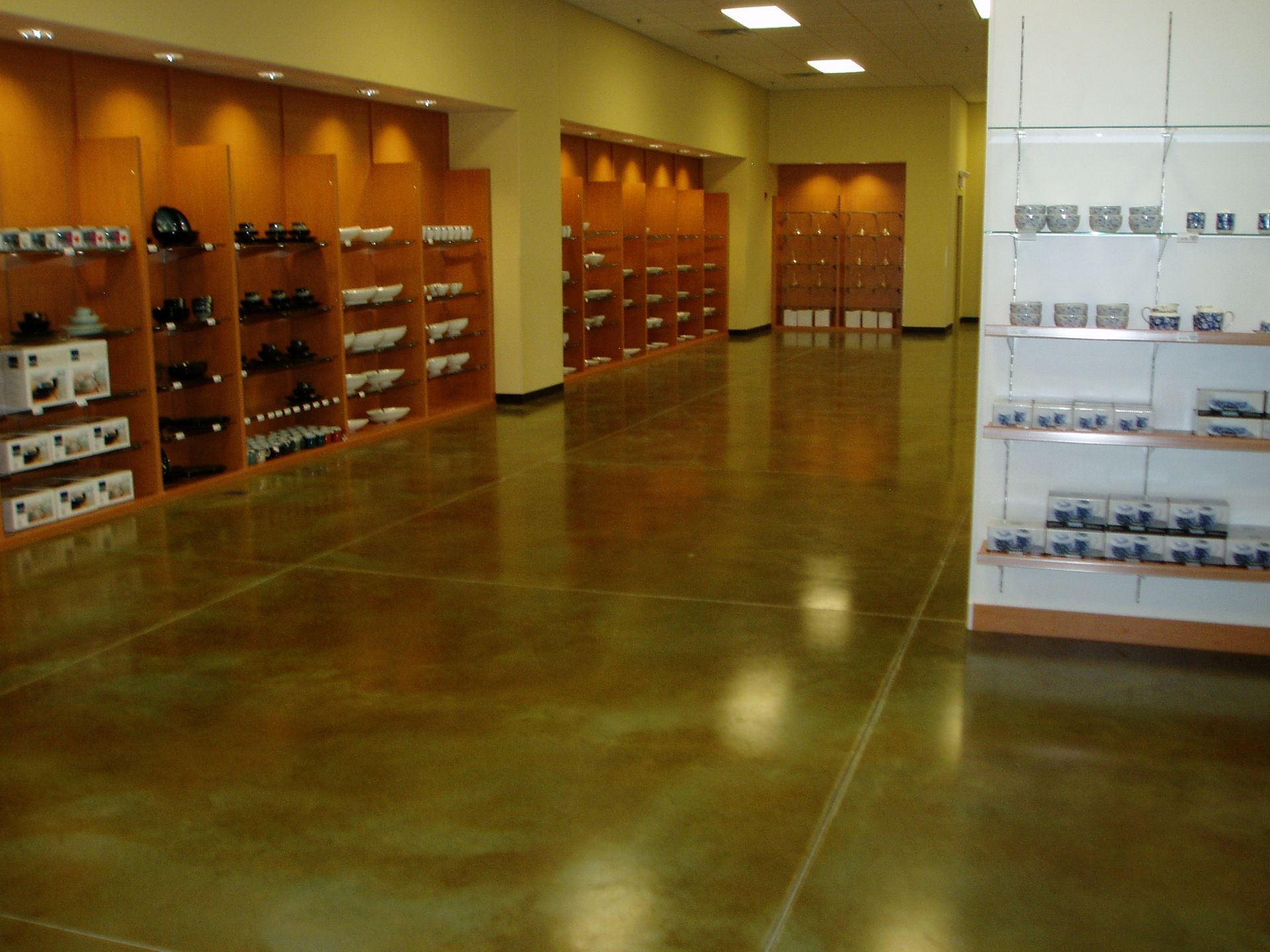 Polished concrete floor in a well-lit showroom with display shelves along the walls.