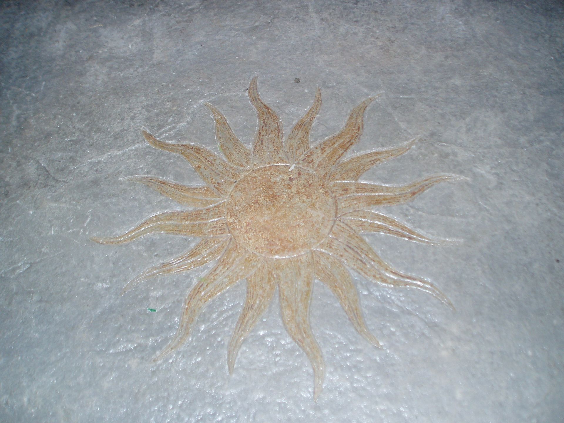 Golden sunburst design on a light gray surface, radiating light.