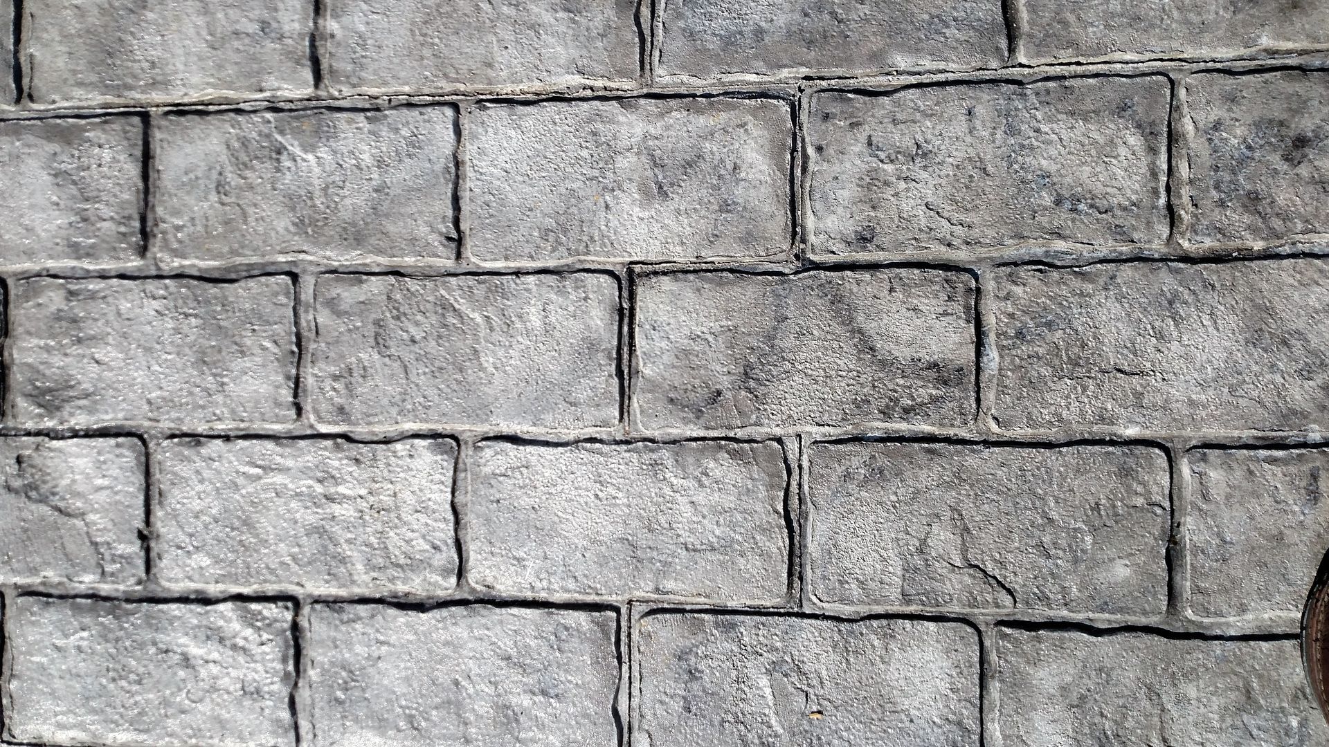Gray, textured concrete bricks arranged in a running bond pattern.