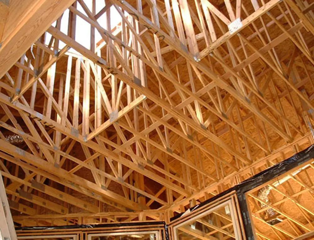 The ceiling of a house under construction is made of wood.