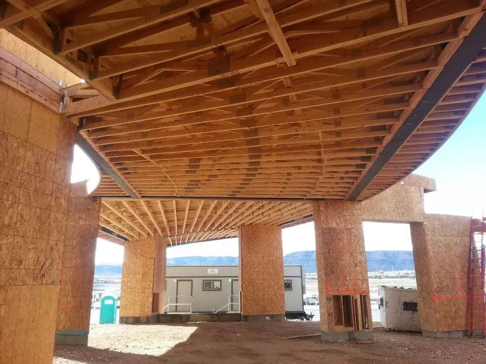 The inside of a building under construction with a green trash can in the background