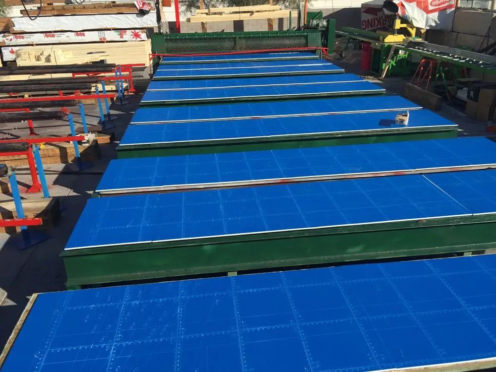 A row of blue tables are sitting on top of each other in a warehouse.