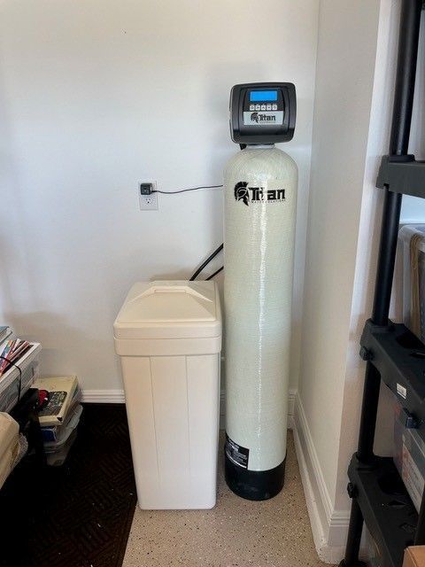 Water softener system: tall white tank with a digital control panel, next to a white salt tank.