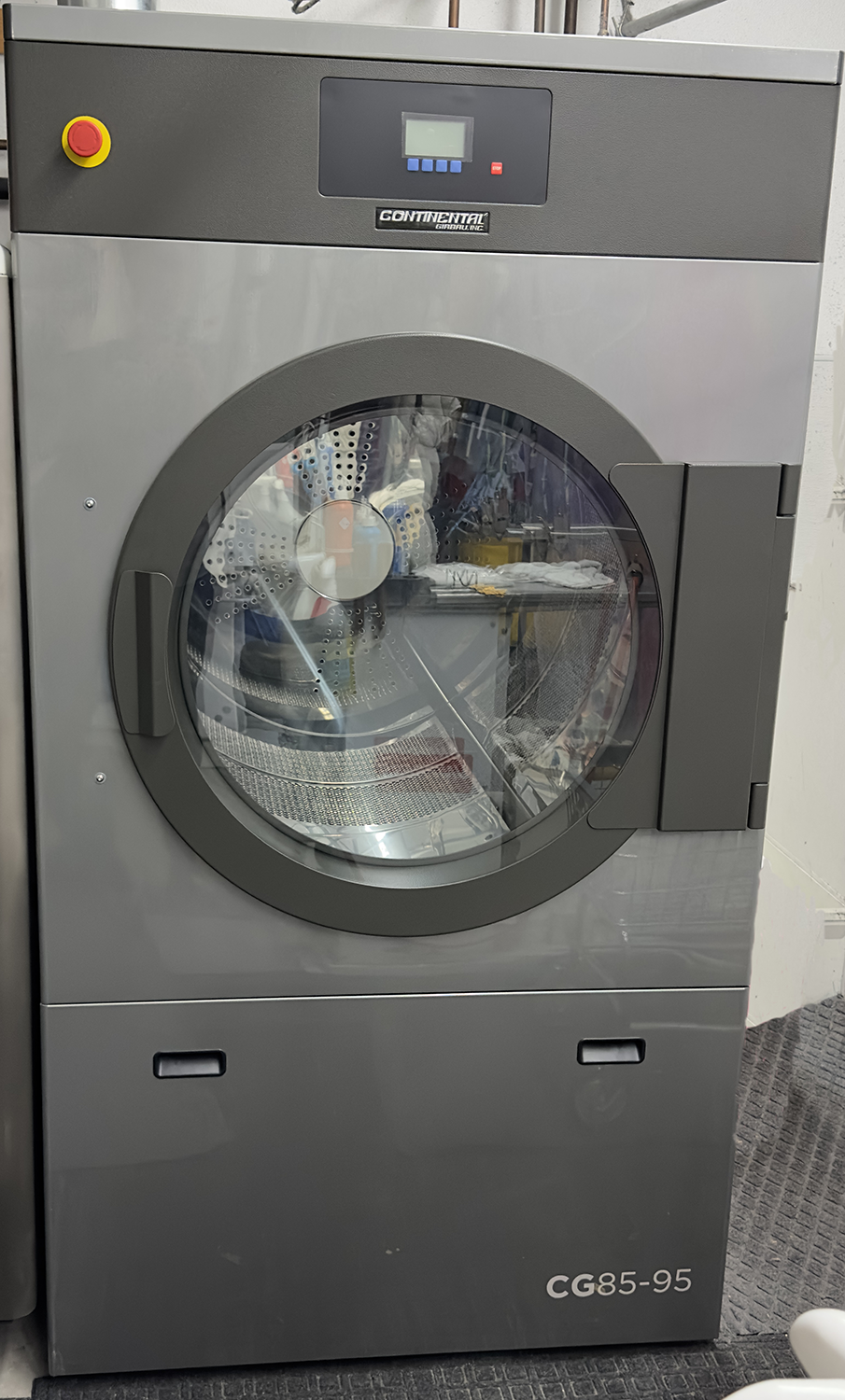 A washing machine is sitting on the floor in a room.