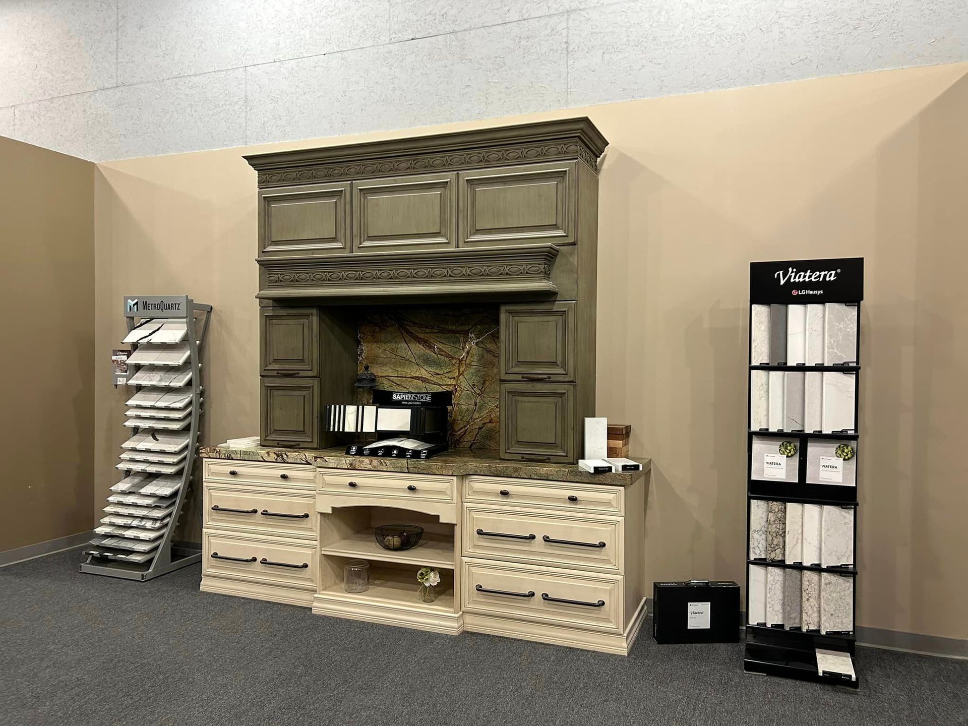 A kitchen with a stove top oven and a display of tiles.