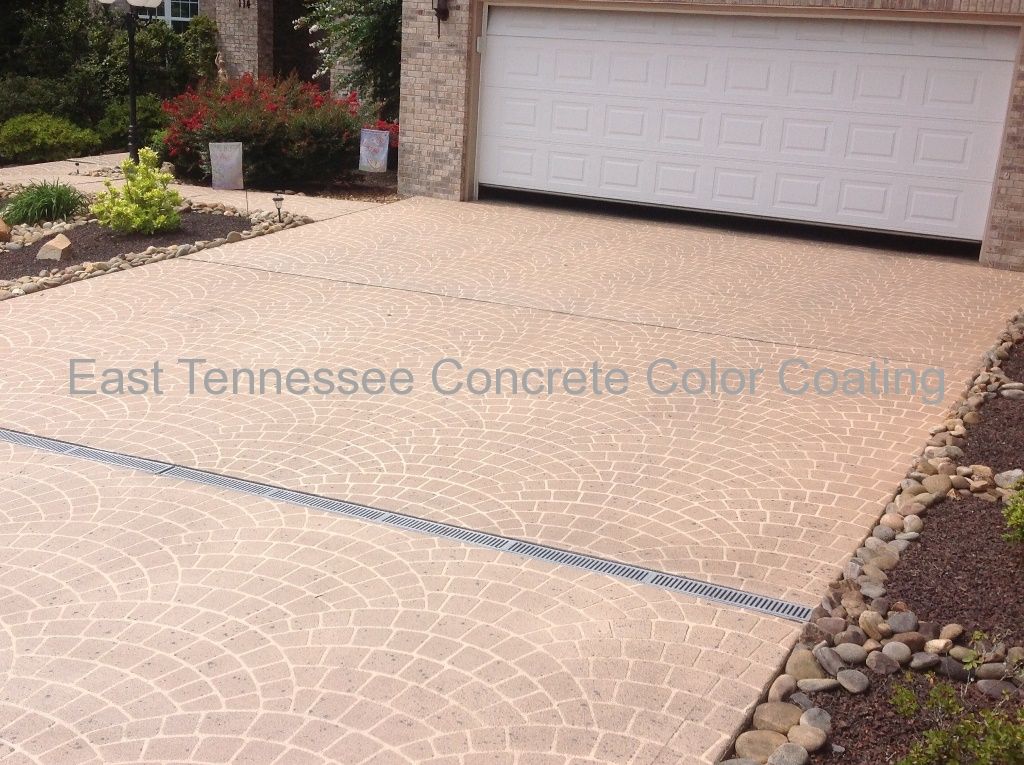 A concrete driveway with a white garage door in the background