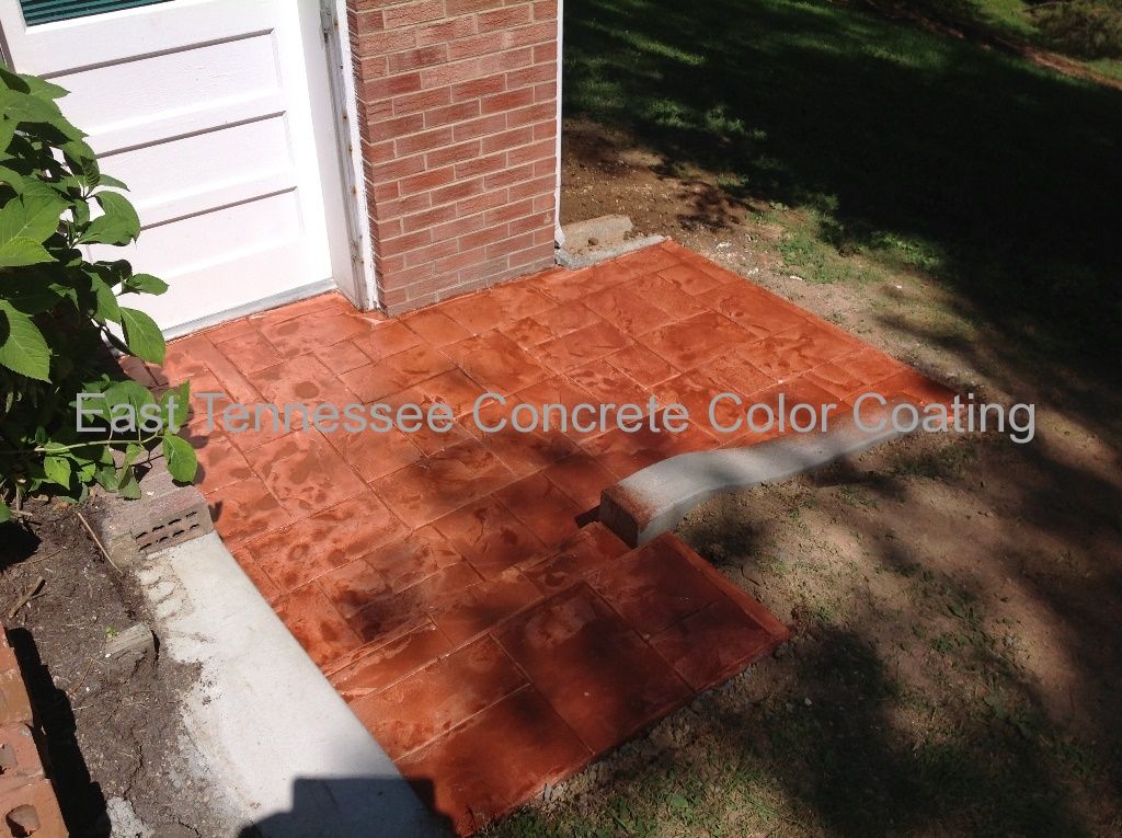 A concrete walkway with a brick wall in the background