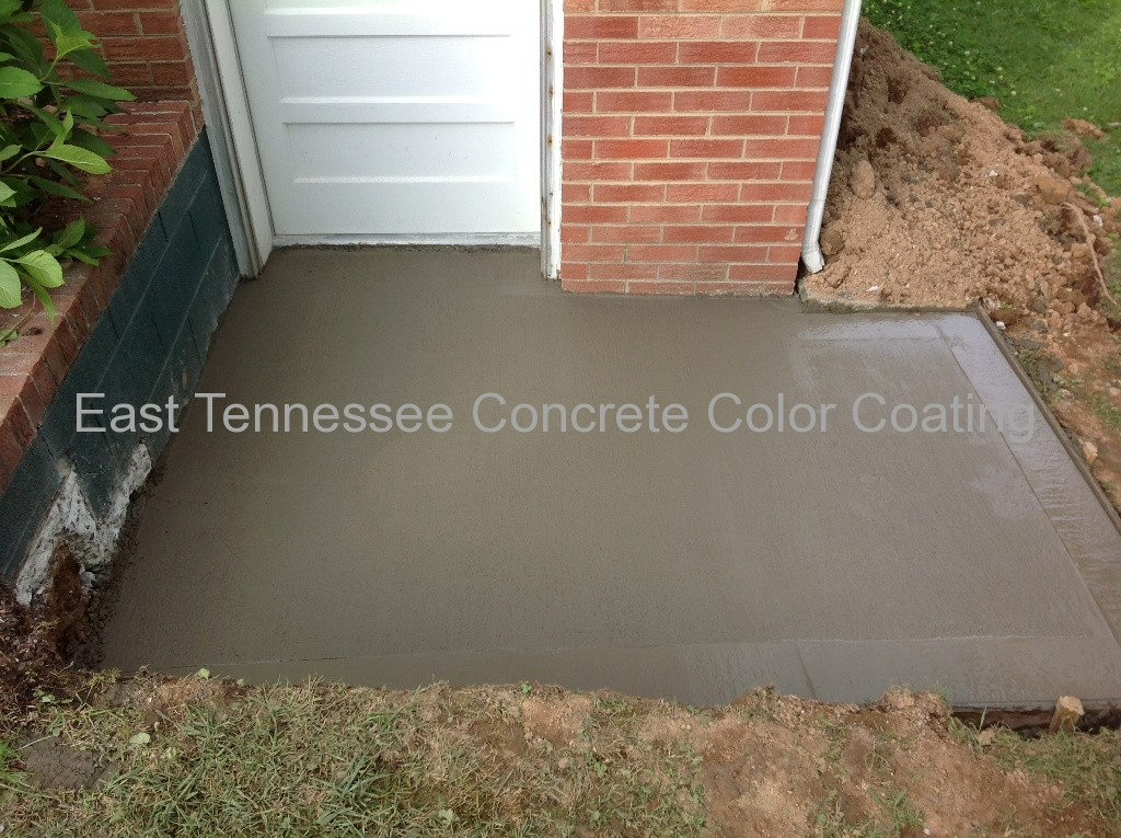 A concrete walkway is being built in front of a brick building.