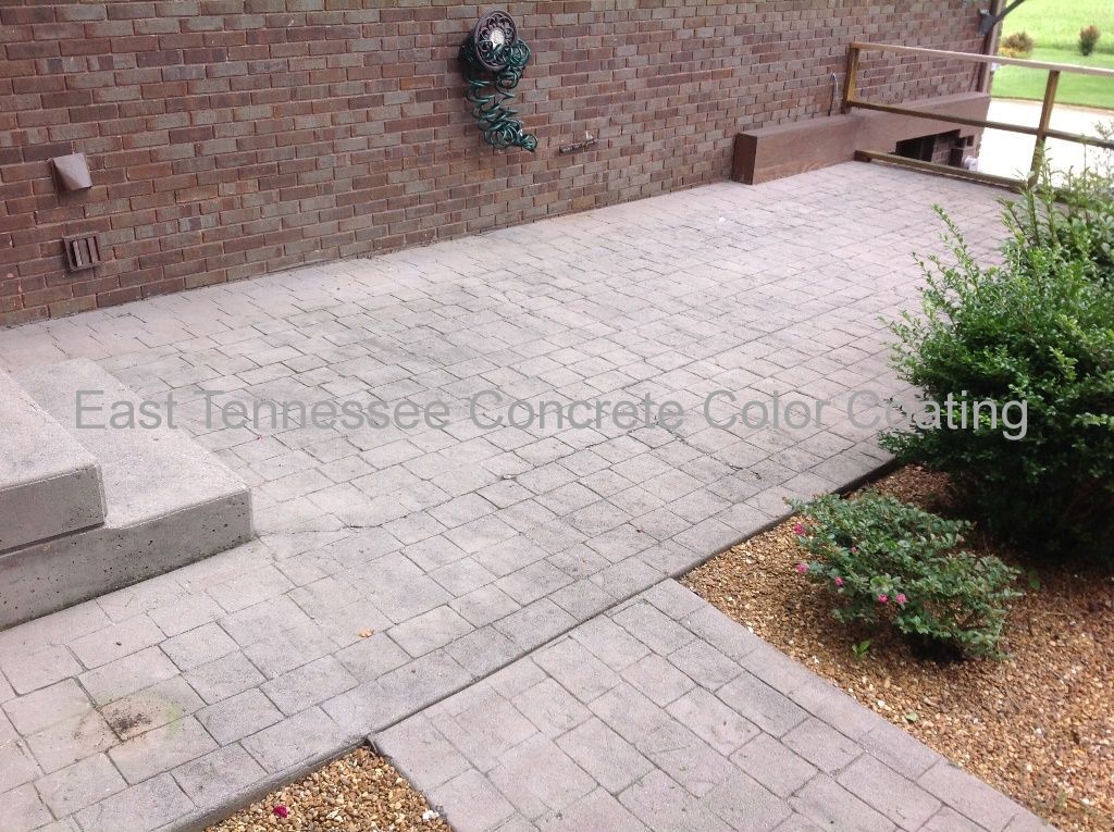 A brick building with a concrete walkway in front of it