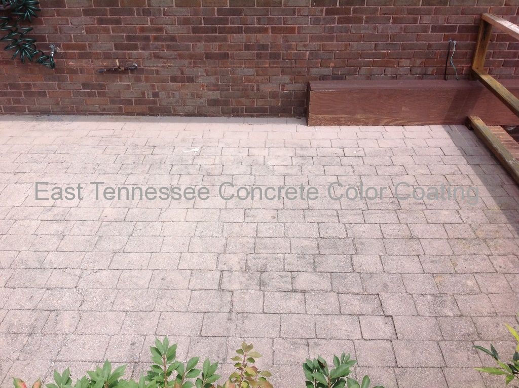 A brick wall behind a concrete patio