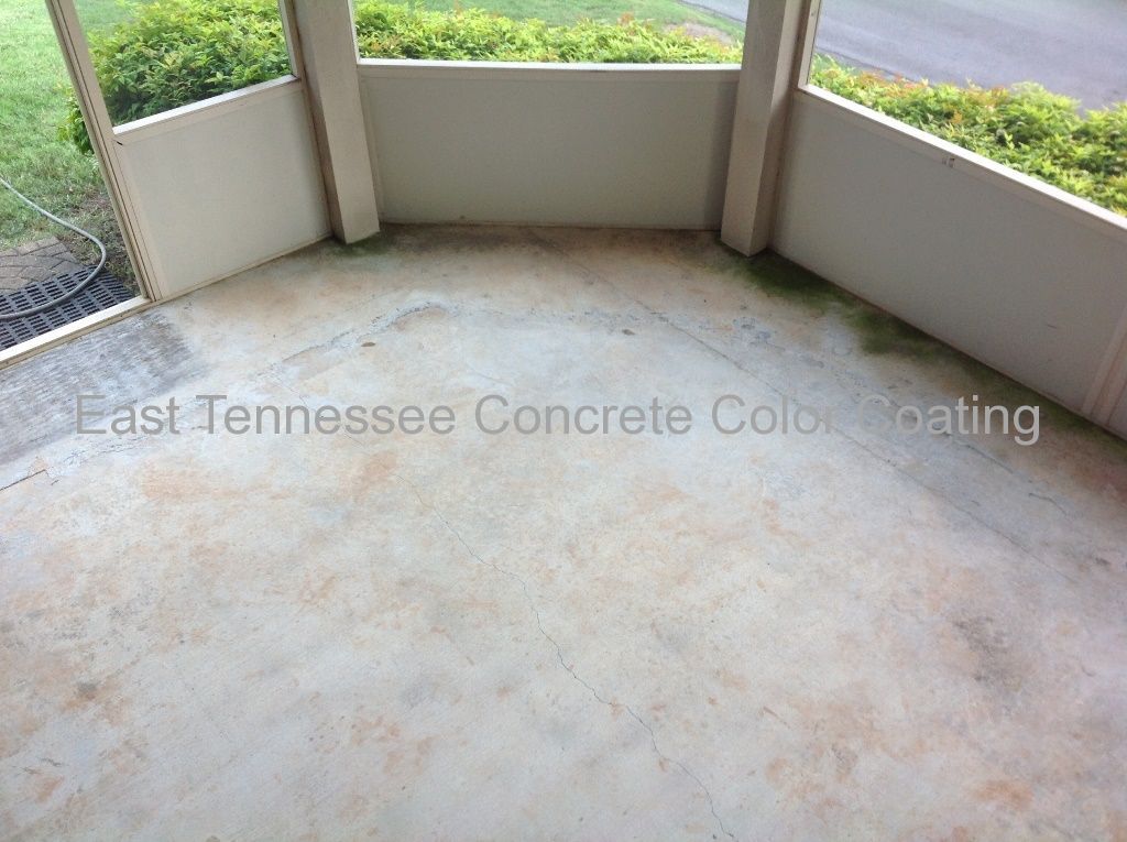 A concrete porch with a view of a lush green field.