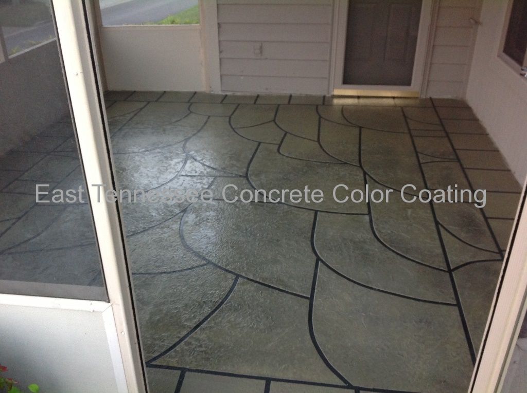 A screened in porch with a concrete flooring