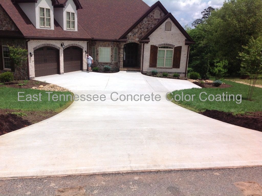 A large house with a concrete driveway in front of it