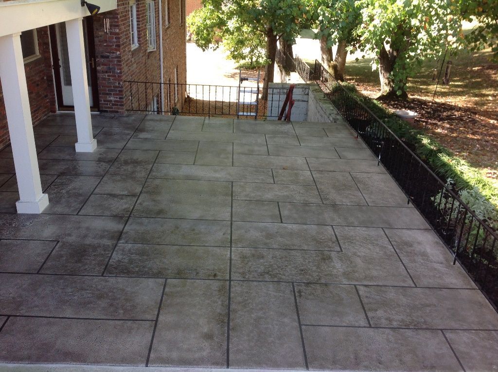 A patio with a brick building in the background