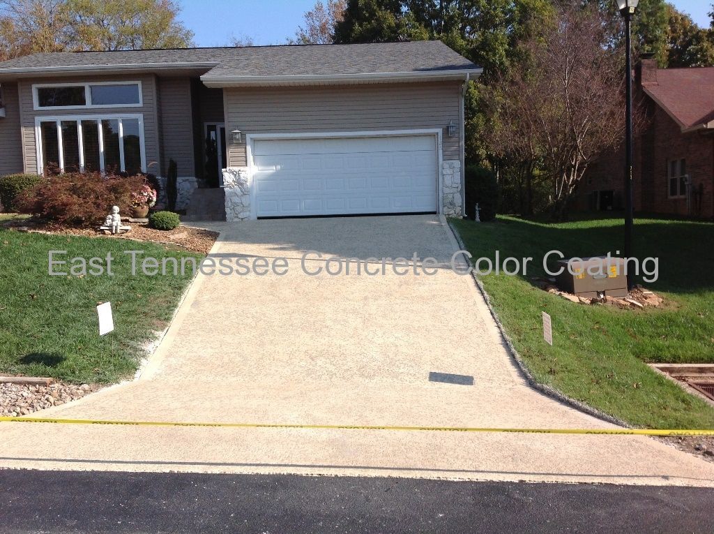 A concrete driveway leading to a house.