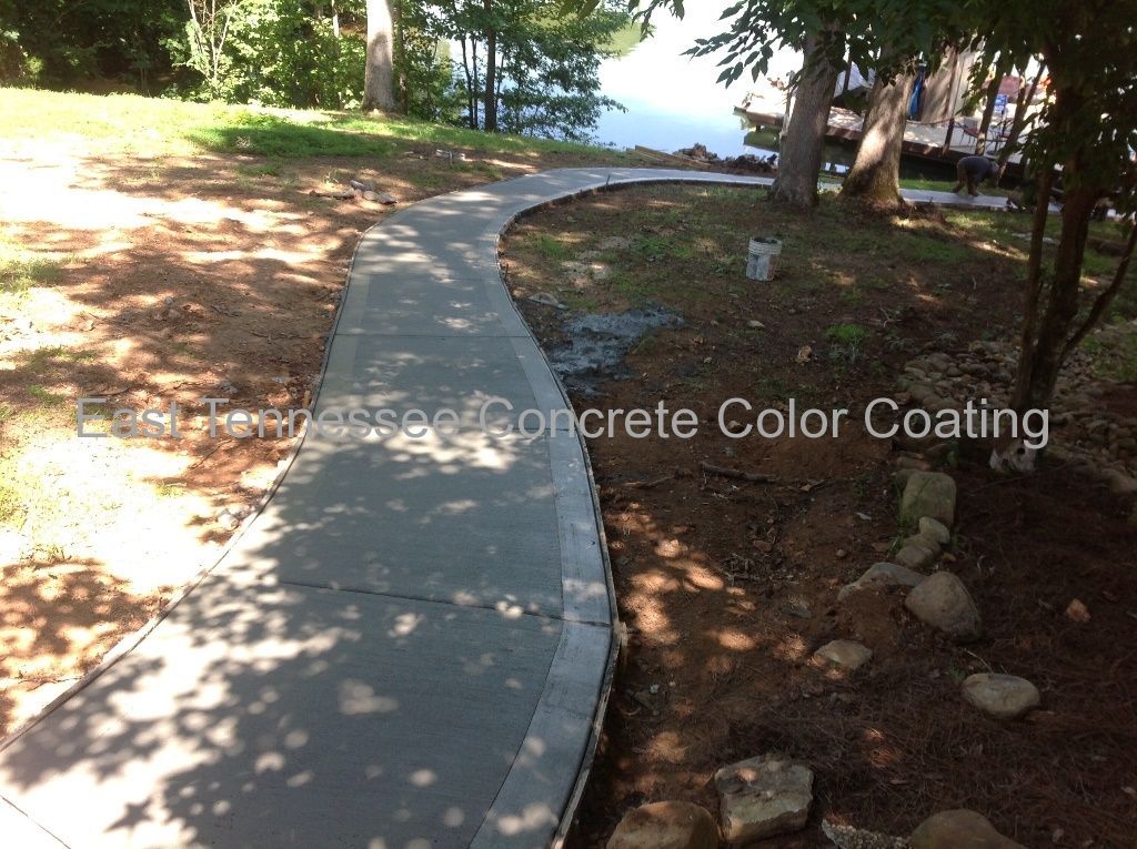 A concrete walkway leading to a body of water