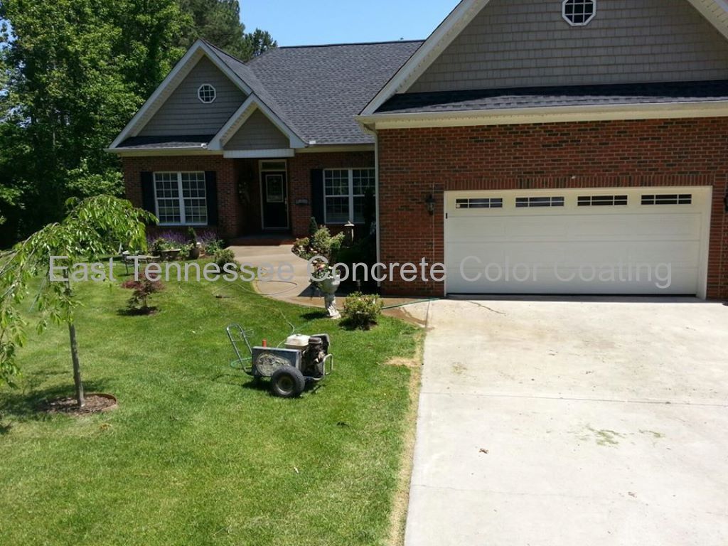 A brick house with a white garage door and a concrete driveway