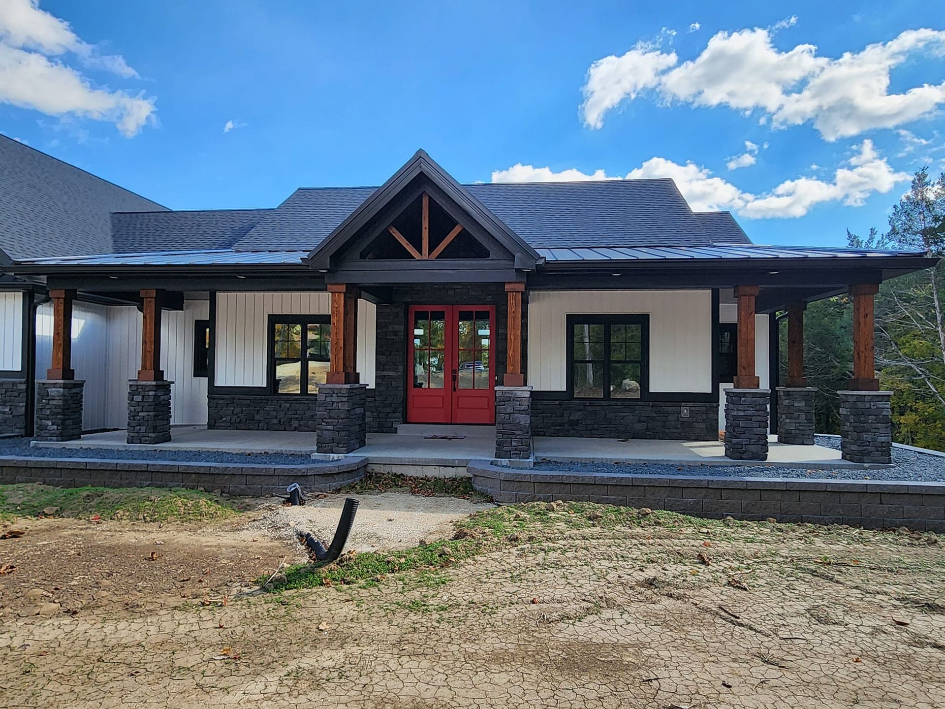 The front of a house with a red door and a porch.