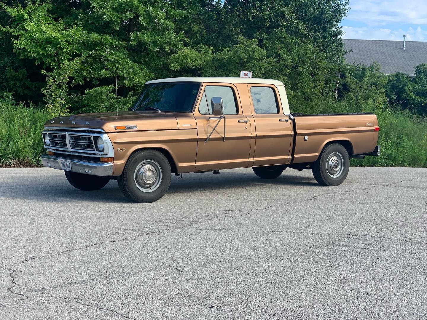 A brown and white pickup truck is parked in a parking lot.