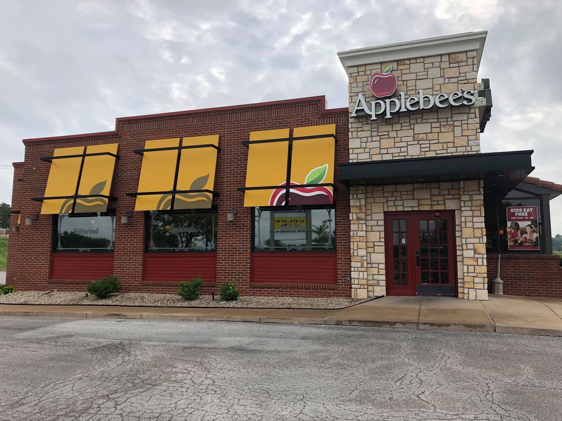 An applebee 's restaurant with yellow awnings on the windows