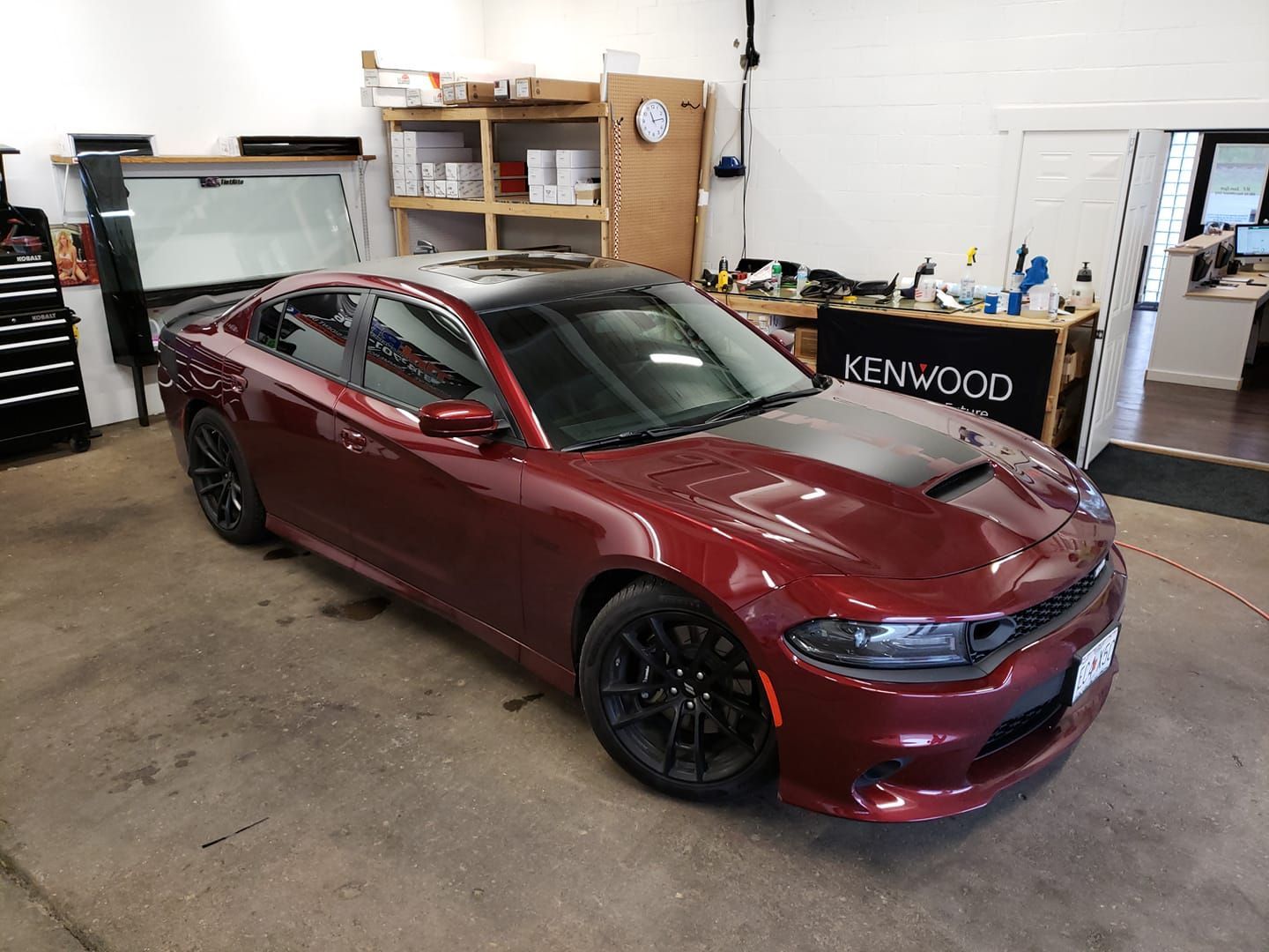 A red dodge charger is parked in a garage.