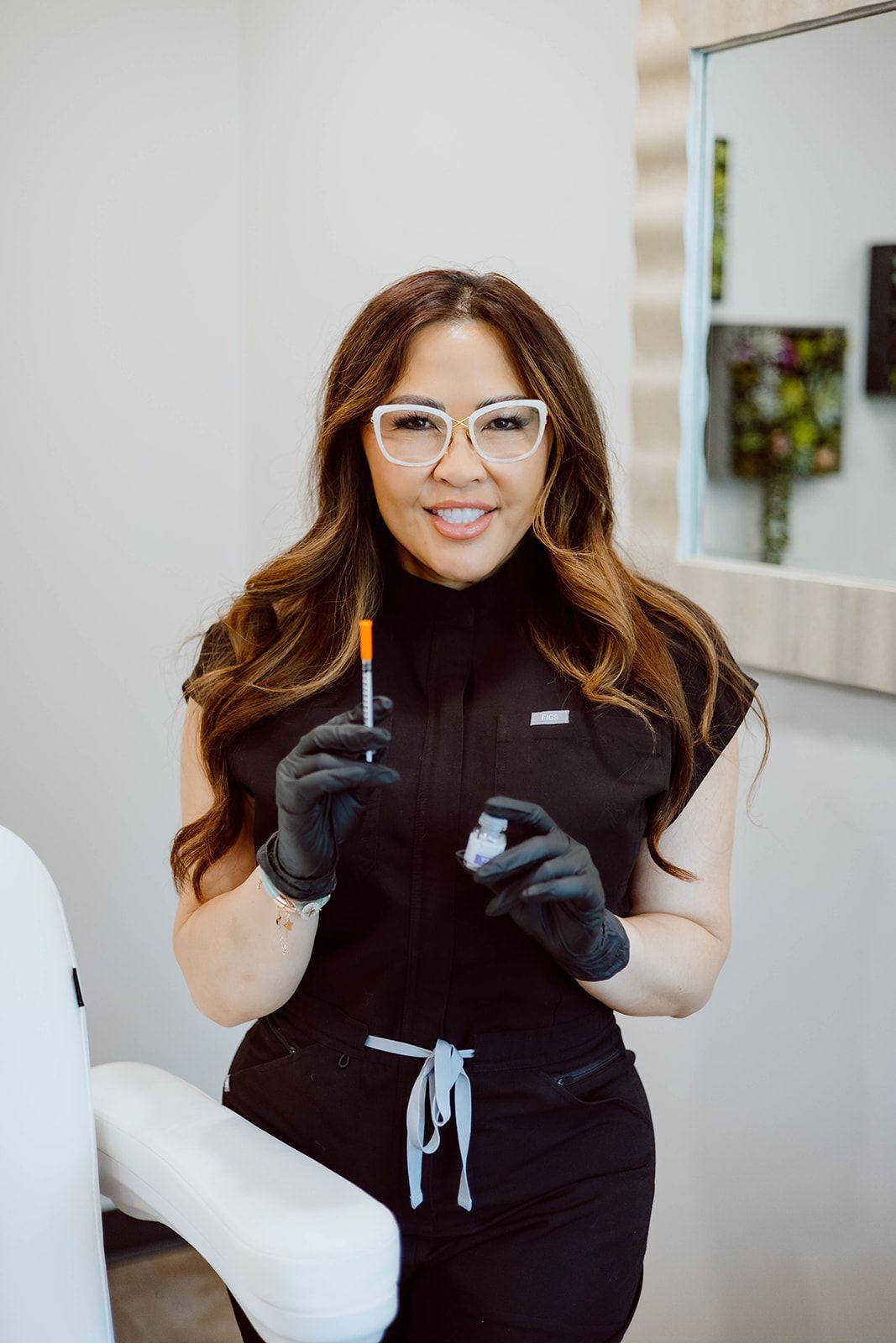 A woman is holding a syringe in her hand and smiling.