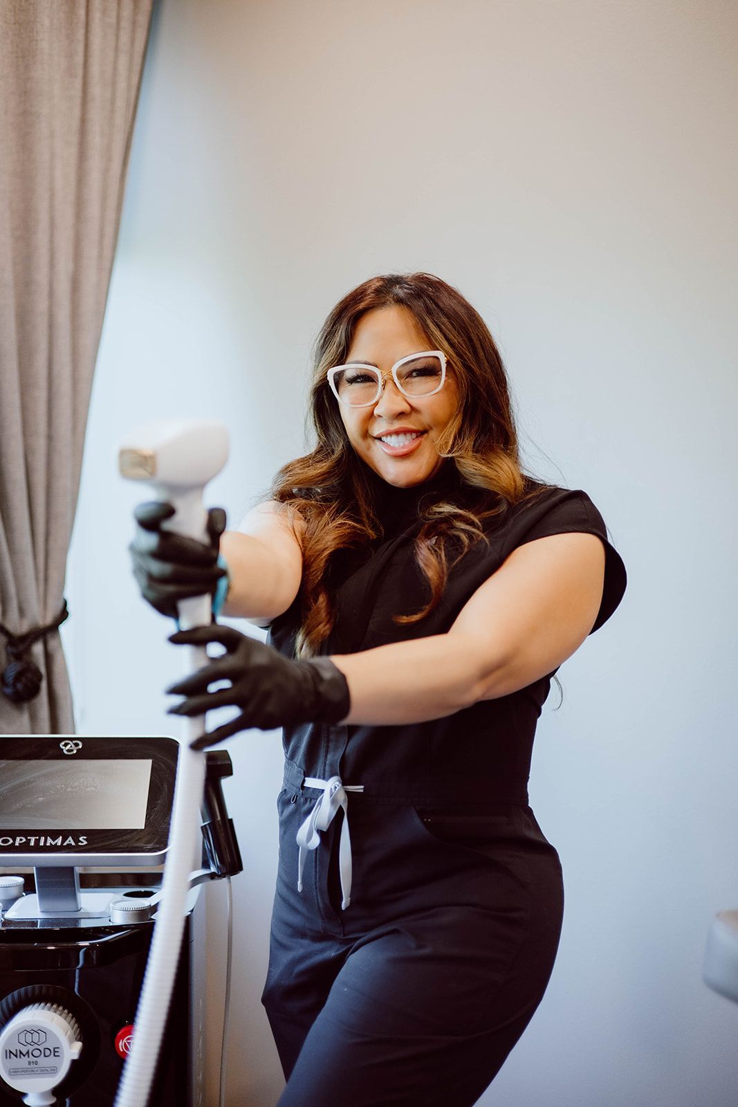 A woman is holding a machine in her hands and smiling.