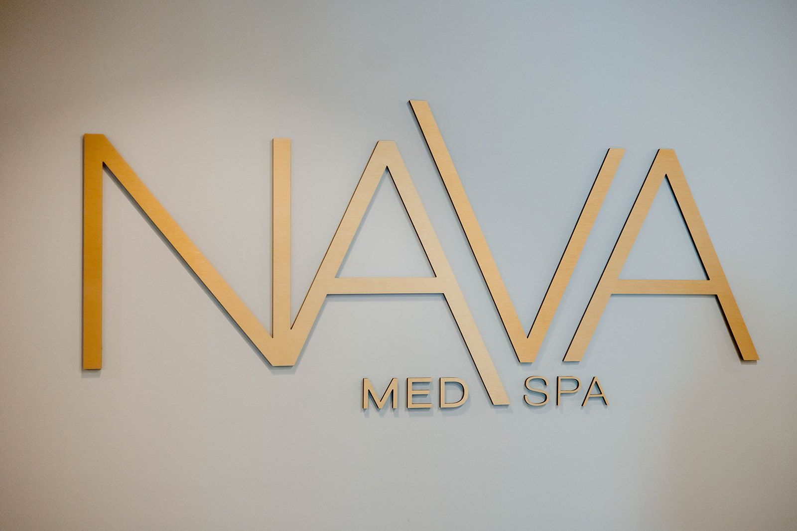 The logo for nava med spa is on a white wall